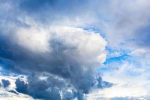 große dunkle regnerische wolke am bewölkten blauen himmel foto