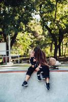 schöne junge Hipster-Mutter und kleiner Sohn im Skatepark foto