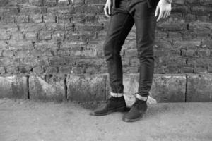 männliches Modell in Jeans auf dem Hintergrund einer Backsteinmauer foto