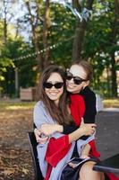 Mädchen umarmt ihre Freundin. Porträt von zwei Freundinnen im Park. foto