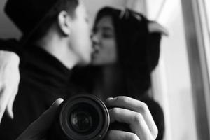 Mann und Frau in schwarzer Kleidung küssen sich foto