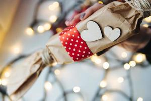 Mädchen, das in der Hand ein Weihnachtsgeschenk hält foto