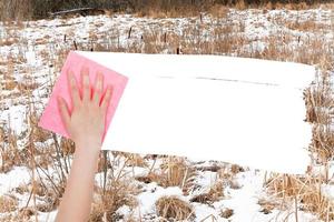Hand löscht gefrorenen Sumpf durch rosa Lappen foto