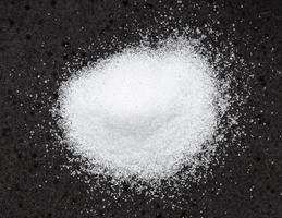 Haufen von kristallinem Erythrit-Zucker auf Schwarz foto