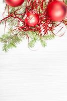 rote Weihnachtsdekorationen und Zweig auf leerem Papier foto