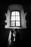 Braut und Bräutigam auf dem Hintergrund eines Fensters. foto