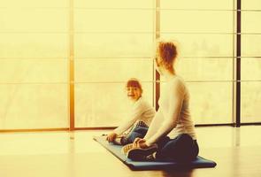 Zwei Mädchen unterschiedlichen Alters machen Yoga foto