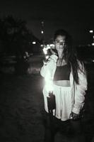 junge Frau mit Fackelschein am Strand bei Nacht foto