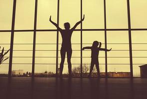 Silhouette von Mutter und Tochter im Fitnessstudio foto