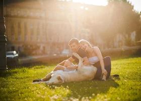 Junge und Mädchen mit Hund lagen auf Gras foto