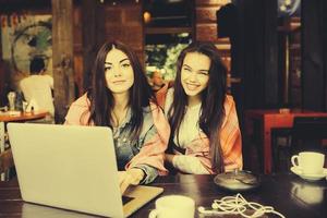 Zwei Mädchen schauen sich etwas im Laptop an foto