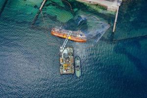 Draufsicht auf einen alten Tanker, der auf Grund lief und umkippte foto