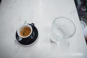 Kaffeebecher und ein Glas Wasser auf einem Tisch foto