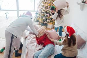 multiethnische freunde haben spaß, sich an silvester auf kissen zu streiten foto