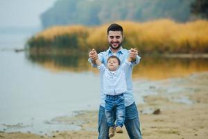 Vater hält die Hände des kleinen Sohnes foto