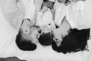 glückliche familie, die sich zusammen auf der matratze entspannt foto