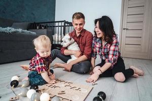 Glückliche Familie spielt zusammen auf dem Boden foto