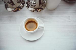 Tasse Cappuccino auf dem weißen Holztisch. foto