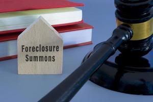 Richterhammer mit Zwangsvollstreckung fordert Wort auf Holzhaus auf blauem Hintergrund. foto