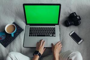 Frau mit Laptop auf ihrem Bett foto