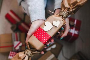 das mädchen hält ein charmantes geschenk für ihren geliebten in den händen foto