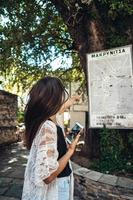 Frau zeigt auf die Karte der Wahrzeichen der Stadt. Makriniza foto