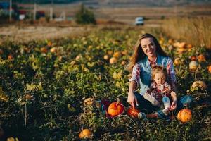 Mutter und Tochter auf einem Feld mit Kürbissen foto