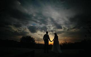 Silhouette des Hochzeitspaares im Feld foto