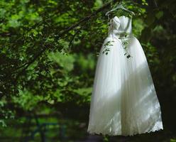 Hochzeitskleid, das an einem Baum hängt foto