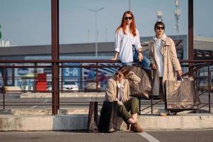 junge Frauen mit Einkaufstüten an einer Bushaltestelle foto