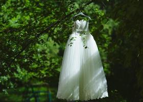 Hochzeitskleid, das an einem Baum hängt foto