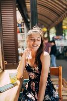 attraktive junge kaukasische frau, die im straßencafé sitzt foto