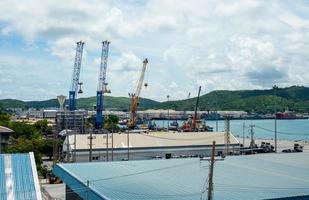 industrieller hafenkran hebt laden exportcontainer an bord im hafen von thailand. foto