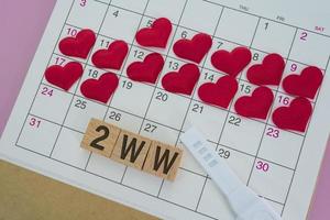 2ww-Wort auf Holzblock mit roter Herzform im Kalender. zweiwöchiges wartekonzept foto