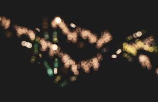 verschwommenes bokeh-licht auf dunklem hintergrund, abstraktes städtisches nachtlicht-bokeh, defokussierter hintergrund für weihnachts- oder feiertagskonzept. foto