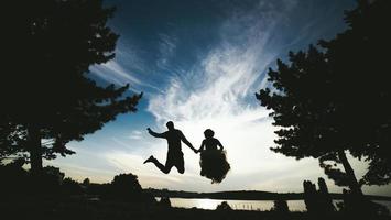Bräutigam und Braut springen gegen den schönen Himmel foto