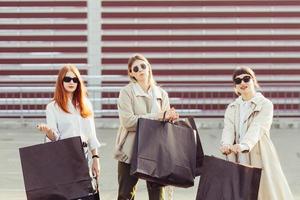 junge frauen mit taschen in den händen posieren für die kamera foto