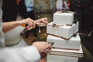 Braut und Bräutigam schneiden Kuchen foto