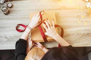 Frau Geschenk in Papier mit rotem Band einwickeln. foto