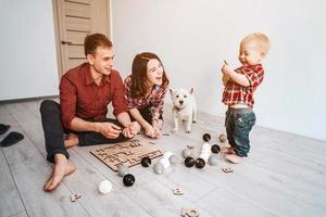 Glückliche Familie spielt zusammen auf dem Boden foto