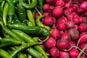 roter Rettich und scharfe Chilischoten auf dem Markt. Gemüse Hintergrund. foto