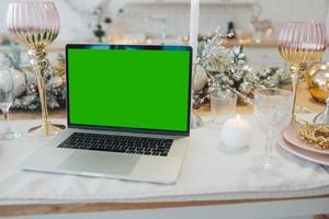 laptop mit grünem bildschirm - chromakey in der nähe von neujahrsdekorationen. Weihnachtsthema. foto