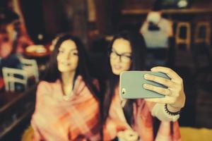 Zwei enge Freunde machen Selfies im Cafe foto
