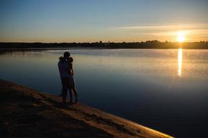 paar im sonnenaufgang am strand foto