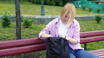 schöne junge Frau, die in ihre Tasche schaut foto