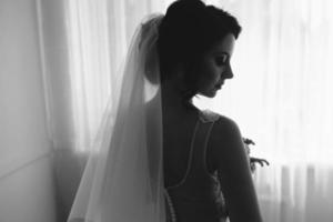 Braut posiert in einem großen Fenster foto