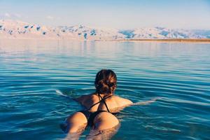 Mädchen entspannt sich und schwimmt im Wasser foto