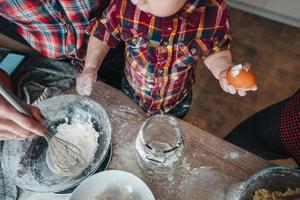 Der kleine Sohn hilft Papa und Mama in der Küche foto