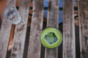 gefrorener grüner matcha latte tee auf holztisch foto