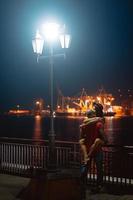 Mann und Mädchen umarmen sich vor dem Hintergrund des Nachthafens foto